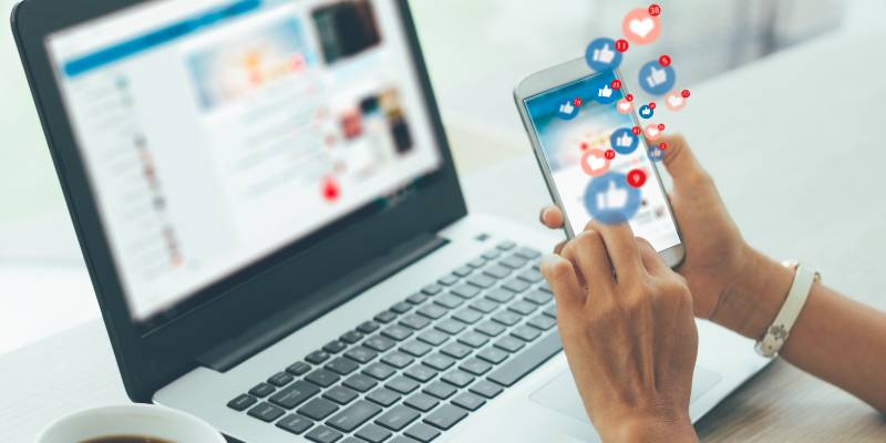 Hand of a woman working in her laptop and mobile